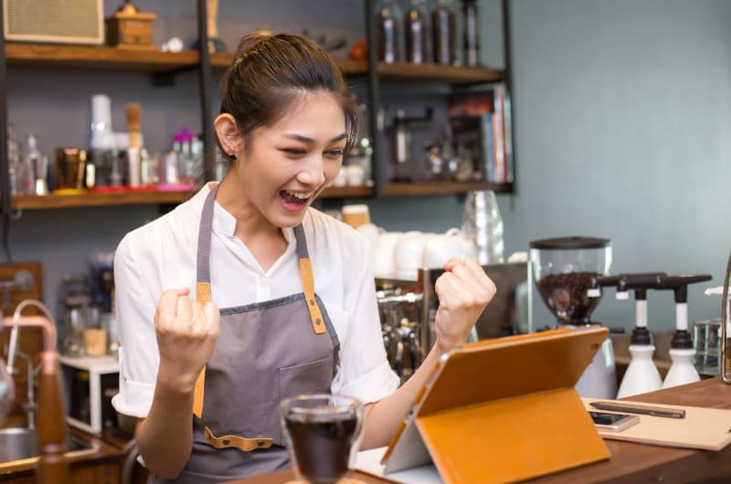 female barista happy looking at computer